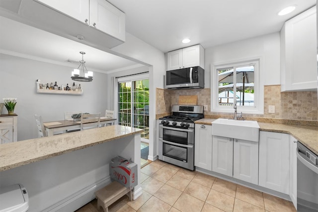 10 Ridge Rd, Cortlandt Manor, NY 10567 - kitchen with stainless steel appliances, a sink, white cabinetry, light tile patterned floors, and ornamental molding