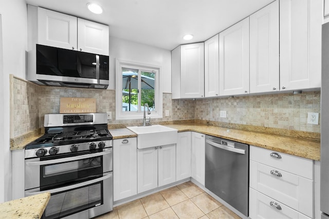 10 Ridge Rd, Cortlandt Manor, NY 10567 - kitchen featuring appliances with stainless steel finishes, a sink, light tile patterned floors, white cabinetry, and recessed lighting