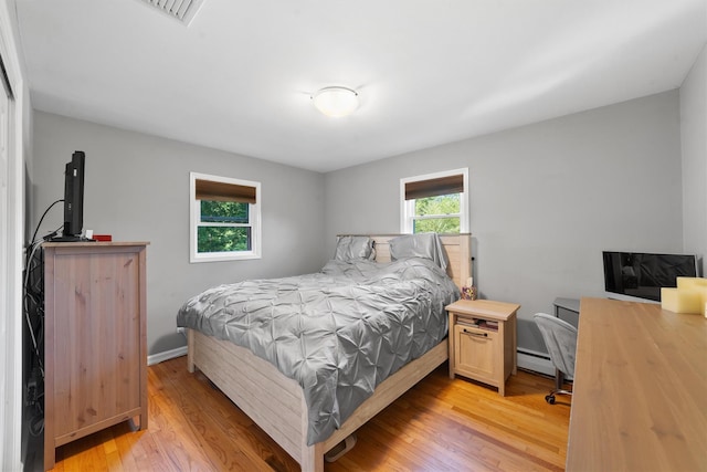 10 Ridge Rd, Cortlandt Manor, NY 10567 - bedroom with a baseboard heating unit, light wood-style floors, and baseboards