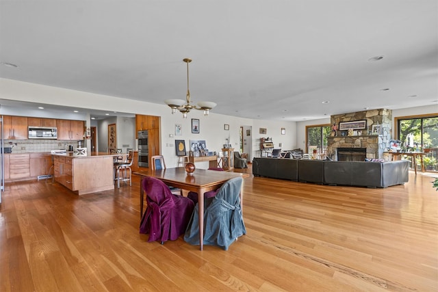 1260 Albany Post Rd, Croton-On-Hudson, NY 10520 - dining space featuring wood finished floors, a stone fireplace, a chandelier, and recessed lighting