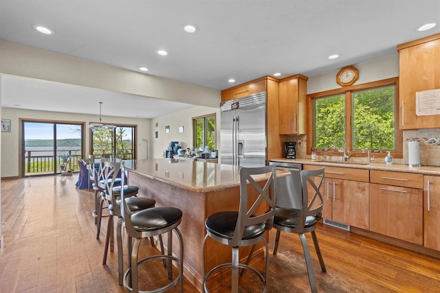 1260 Albany Post Rd, Croton-On-Hudson, NY 10520 - kitchen with stainless steel appliances, hardwood / wood-style flooring, recessed lighting, a kitchen bar, and a kitchen island