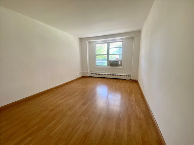 98-05 63rd Rd Unit 1C, Rego Park, NY 11374 - empty room with baseboard heating, light wood finished floors, baseboards, and cooling unit