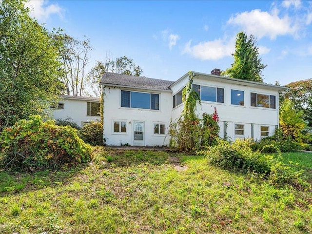 58 Hathorn Blvd, Port Jervis, NY 12771 - back of house with a chimney, a yard, and stucco siding