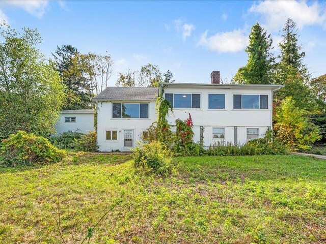 58 Hathorn Blvd, Port Jervis, NY 12771 - view of front of property with a front lawn, a chimney, and stucco siding