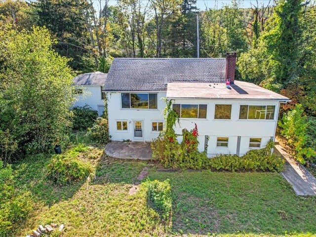 58 Hathorn Blvd, Port Jervis, NY 12771 - view of front of house with a chimney, stucco siding, and a front lawn