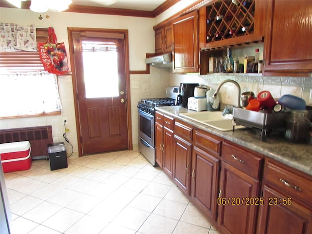 1 Cheshire Ln, Yonkers, NY 10710 - kitchen featuring stainless steel range with gas stovetop, radiator heating unit, under cabinet range hood, light tile patterned flooring, and decorative backsplash