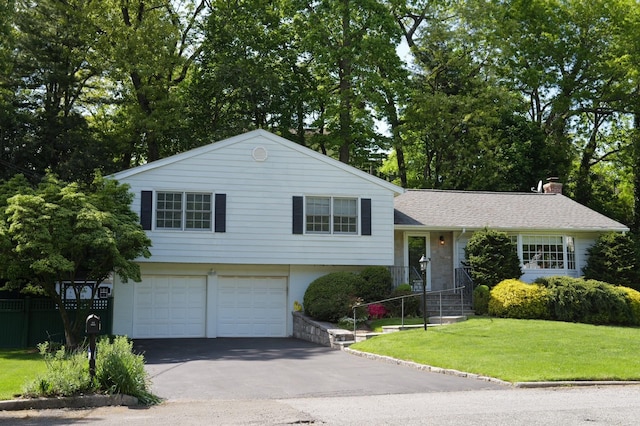 split level home with an attached garage, driveway, a chimney, and a shingled roof