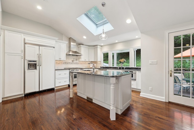 56 Rolling Way, New Rochelle, NY 10804 - kitchen with high quality appliances, wall chimney range hood, a skylight, vaulted ceiling, and dark wood-style floors