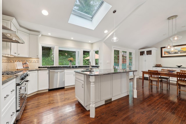 56 Rolling Way, New Rochelle, NY 10804 - kitchen with appliances with stainless steel finishes, under cabinet range hood, healthy amount of natural light, vaulted ceiling, and a skylight