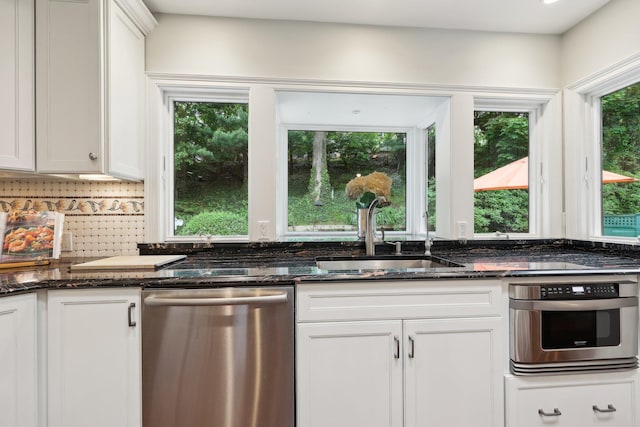 56 Rolling Way, New Rochelle, NY 10804 - kitchen with appliances with stainless steel finishes, a sink, tasteful backsplash, dark stone countertops, and white cabinets