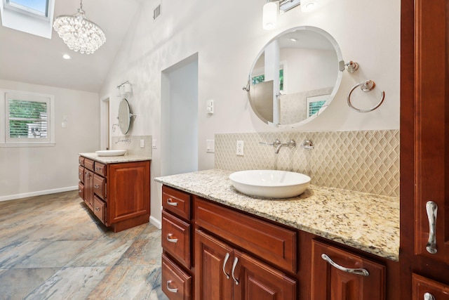 56 Rolling Way, New Rochelle, NY 10804 - full bath featuring backsplash, vaulted ceiling, two vanities, a chandelier, and baseboards
