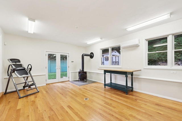 56 Rolling Way, New Rochelle, NY 10804 - workout room featuring a wood stove, an AC wall unit, french doors, and wood finished floors