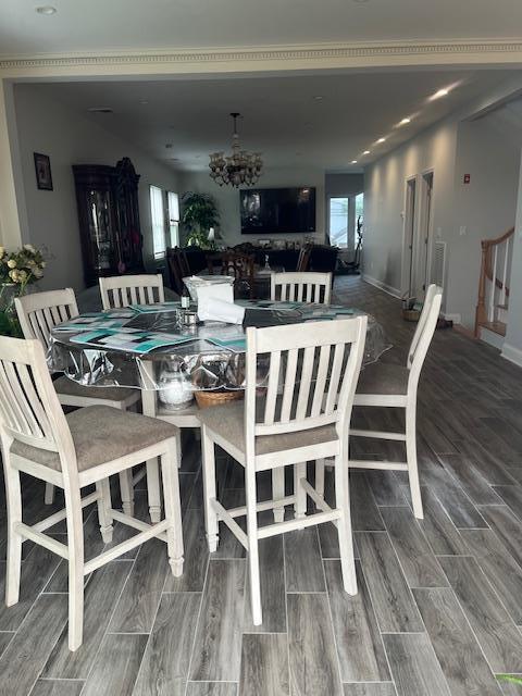 dining space featuring a chandelier, wood finished floors, and baseboards