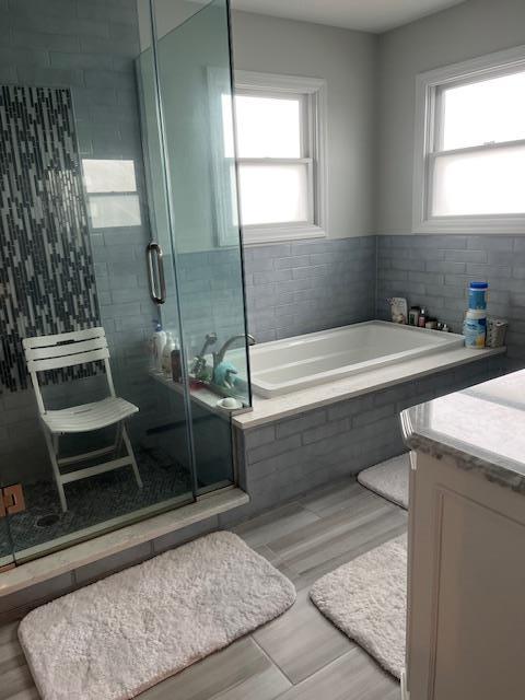 bathroom featuring plenty of natural light, a bath, and wood finished floors