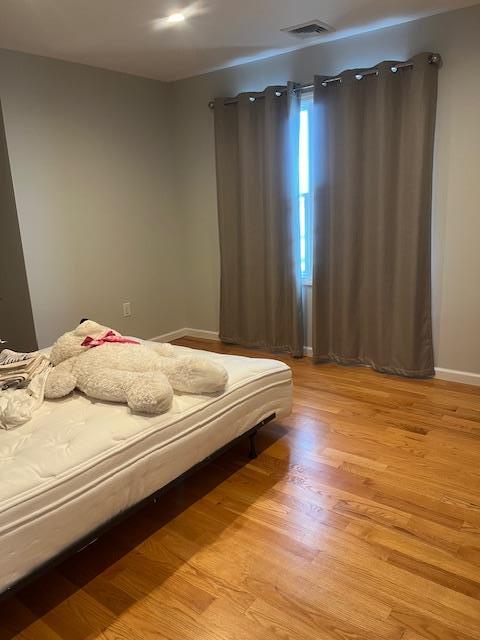 bedroom featuring light wood-style floors and baseboards