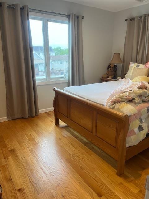 bedroom with light wood-type flooring and baseboards