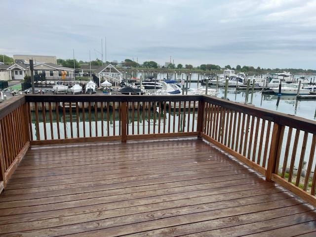 wooden deck featuring a water view and a boat dock