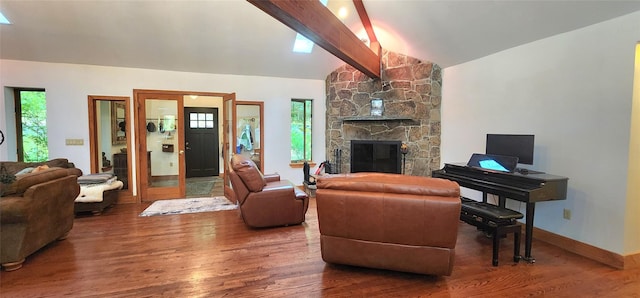 living area featuring wood finished floors, a stone fireplace, and baseboards