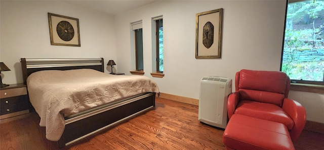 bedroom featuring wood finished floors and baseboards