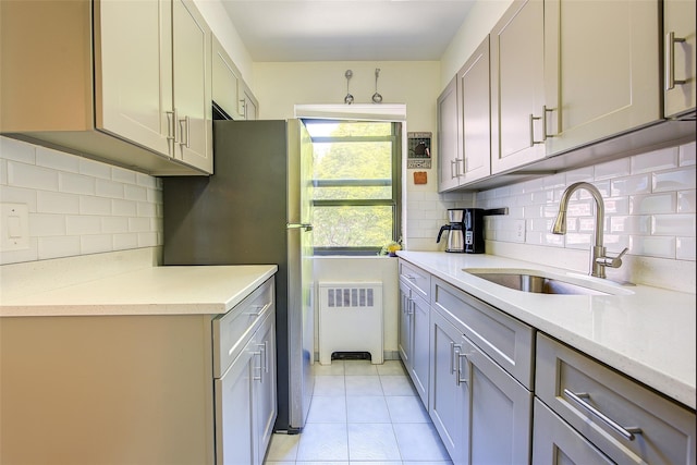 kitchen featuring a sink, light countertops, and backsplash