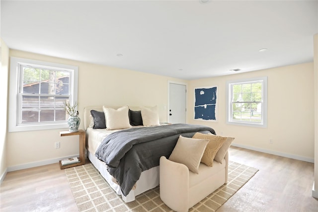 bedroom with light wood-type flooring and baseboards