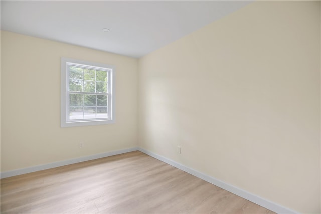 unfurnished room with baseboards and light wood-type flooring