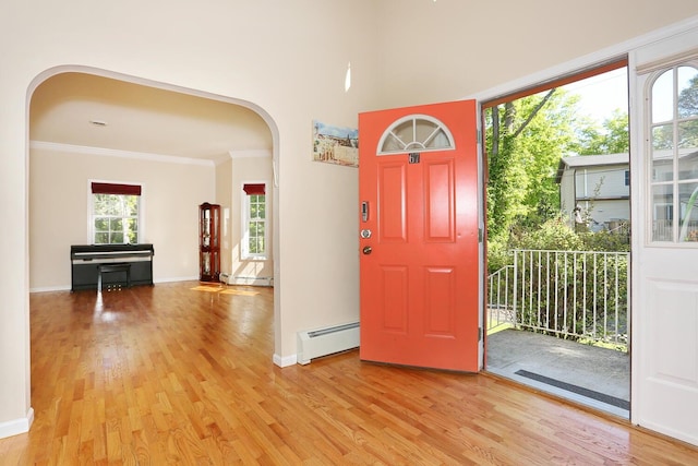 67 N Airmont Rd, Suffern, NY 10901 - foyer entrance featuring arched walkways, baseboard heating, light wood-style flooring, and crown molding