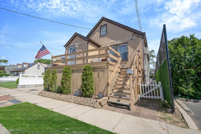 view of front of property featuring stairs, fence, and a wooden deck