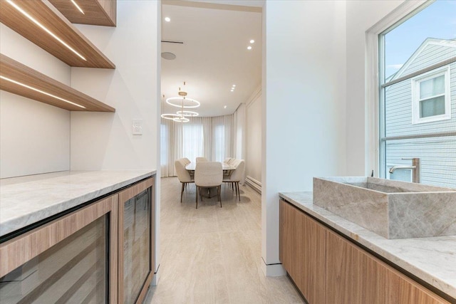 357 Argyle, Cedarhurst, NY 11516 - bar area with plenty of natural light, light wood-style floors, a sink, and a chandelier