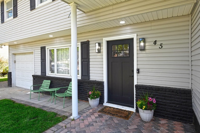 45 Longworth Ave, Dix Hills, NY 11746 - view of exterior entry featuring a porch and a garage
