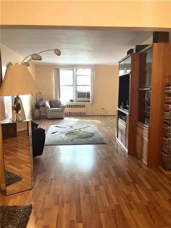 2626 Homecrest Ave Unit 2H, Brooklyn, NY 11235 - living room with radiator, wood finished floors, and cooling unit
