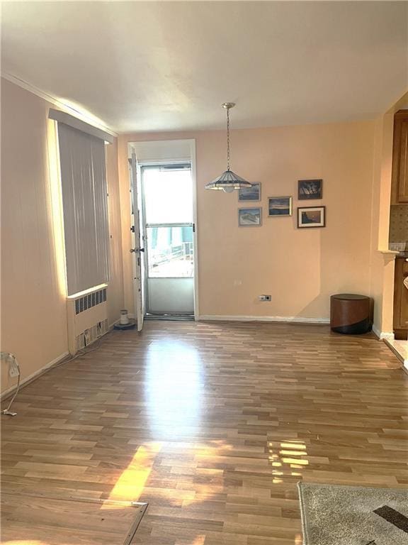2626 Homecrest Ave Unit 2H, Brooklyn, NY 11235 - unfurnished dining area featuring radiator, wood finished floors, and baseboards