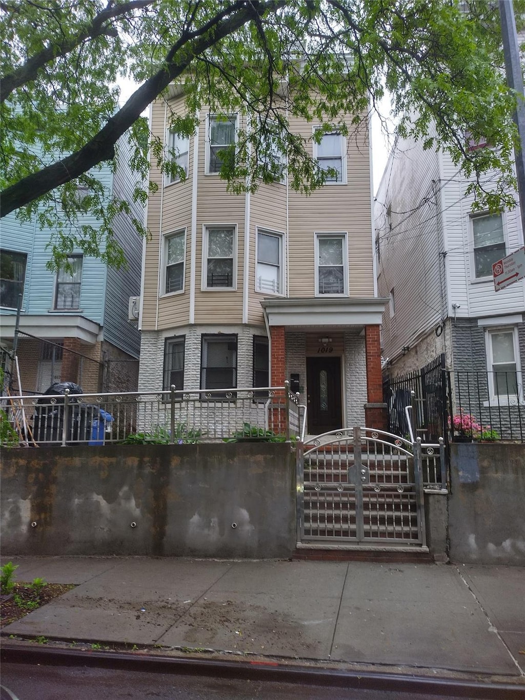 1019 Woodycrest Ave, Bronx, NY 10452 - view of front of home with a fenced front yard, a gate, and brick siding