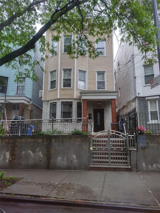 1019 Woodycrest Ave, Bronx, NY 10452 - view of front of home with a fenced front yard, a gate, and brick siding