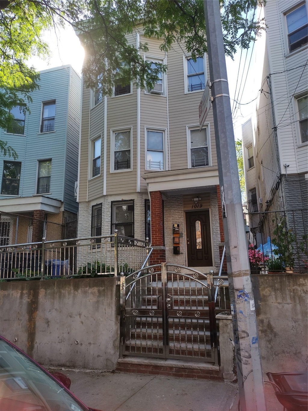 1019 Woodycrest Ave, Bronx, NY 10452 - townhome / multi-family property featuring a fenced front yard and brick siding