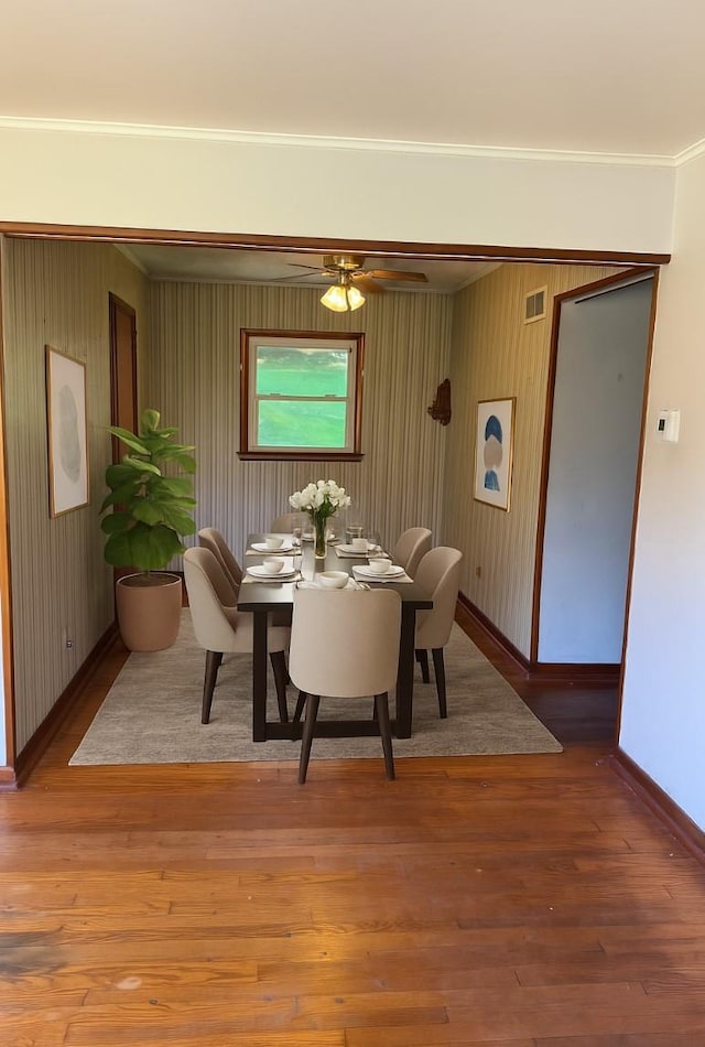 21 Patricia Ave, Fishkill, NY 12524 - dining area featuring ornamental molding, baseboards, ceiling fan, wood finished floors, and wood walls