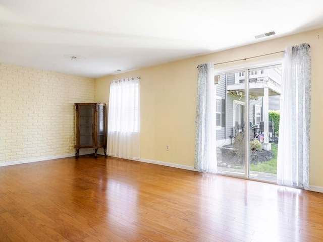 902 Commons Way Unit B, Fishkill, NY 12524 - unfurnished room with wood finished floors, brick wall, and baseboards