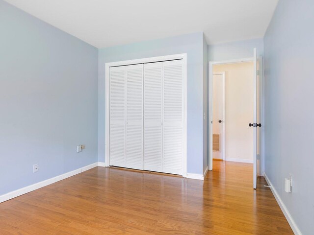 902 Commons Way Unit B, Fishkill, NY 12524 - unfurnished bedroom featuring baseboards, wood finished floors, and a closet