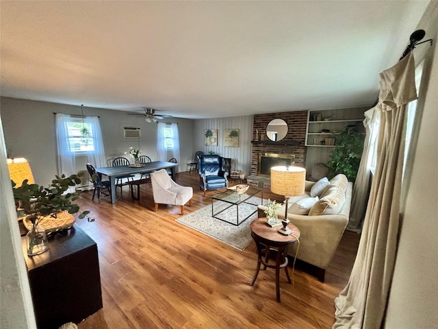 49 N Chestnut St, Beacon, NY 12508 - living area with wood finished floors, ceiling fan, a wall unit AC, a fireplace, and built in shelves
