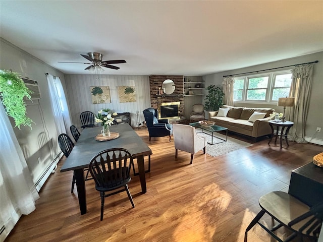 49 N Chestnut St, Beacon, NY 12508 - dining space with baseboard heating, wood finished floors, a ceiling fan, and a brick fireplace