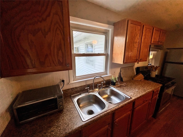 49 N Chestnut St, Beacon, NY 12508 - kitchen with brown cabinets, gas range, dark countertops, and tasteful backsplash