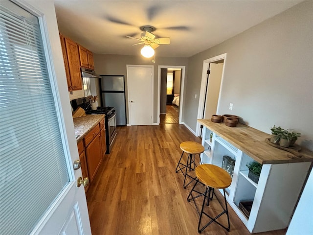 49 N Chestnut St, Beacon, NY 12508 - kitchen with appliances with stainless steel finishes, brown cabinets, open shelves, dark wood-style flooring, and a ceiling fan