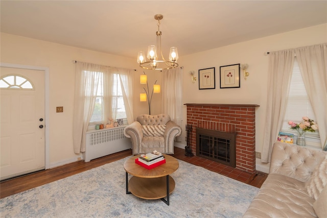 964 Pemart Ave, Peekskill, NY 10566 - living area featuring wood finished floors, a chandelier, healthy amount of natural light, and a brick fireplace