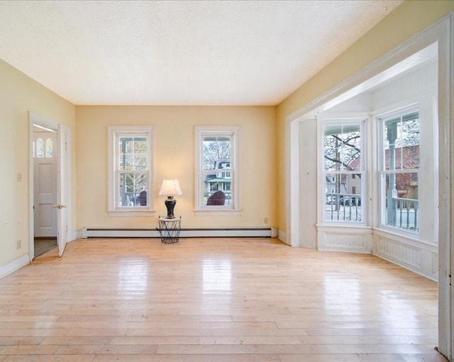 239-241 Hurleyville Main St, Hurleyville, NY 12747 - unfurnished room featuring a baseboard radiator, light wood-style floors, and plenty of natural light