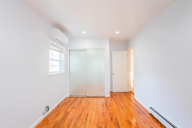 42-51247THST 247th St, Little Neck, NY 11363 - unfurnished bedroom with a baseboard heating unit, a wall mounted air conditioner, a closet, light wood-type flooring, and baseboards