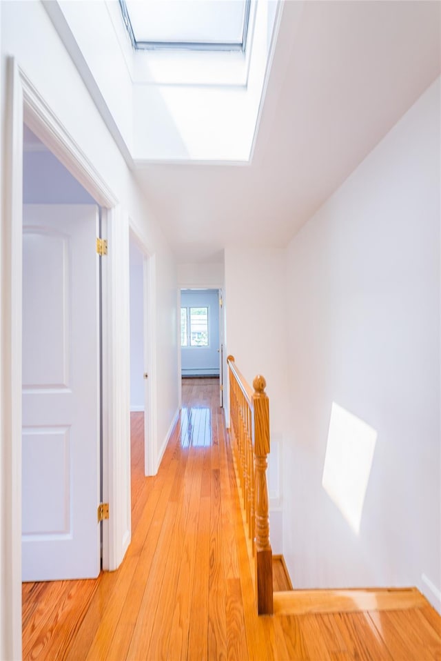 42-51247THST 247th St, Little Neck, NY 11363 - corridor with an upstairs landing, light wood-type flooring, a skylight, and baseboards