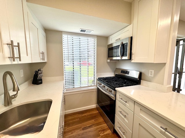 17 Cheyenne Ct Unit C17, Coram, NY 11727 - kitchen with stainless steel appliances, a sink, white cabinets, dark wood-type flooring, and baseboards