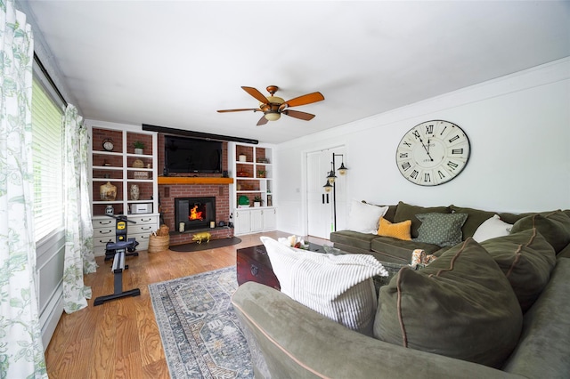 136 Foggintown Rd, Brewster, NY 10509 - living room featuring ceiling fan, a fireplace, wood finished floors, and crown molding