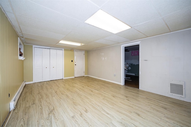 136 Foggintown Rd, Brewster, NY 10509 - finished below grade area with a baseboard heating unit, light wood finished floors, and a paneled ceiling