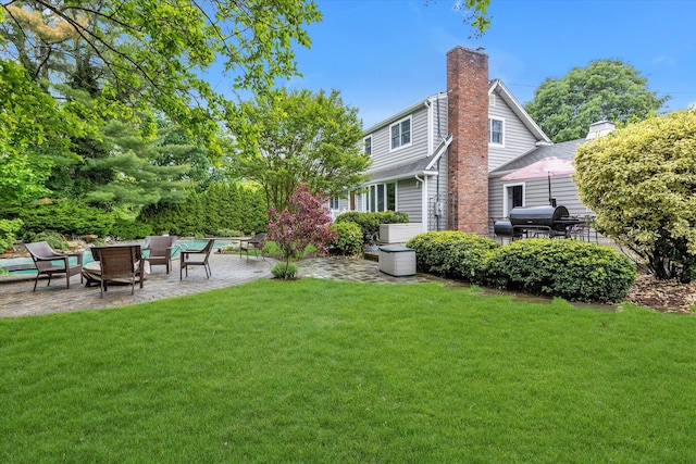 back of house featuring a patio, a lawn, a chimney, and an outdoor hangout area